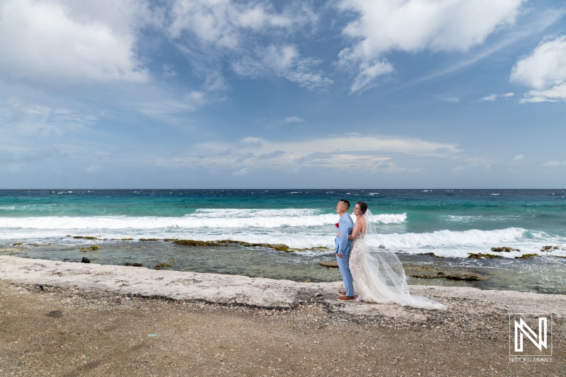 Couple celebrates love during wedding ceremony at Kokomo Beach in Curacao under a beautiful sky by the ocean