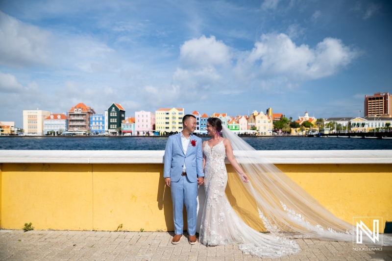 Wedding celebration at Kokomo Beach in Curacao featuring a beautiful couple against a vibrant backdrop of colorful buildings by the water