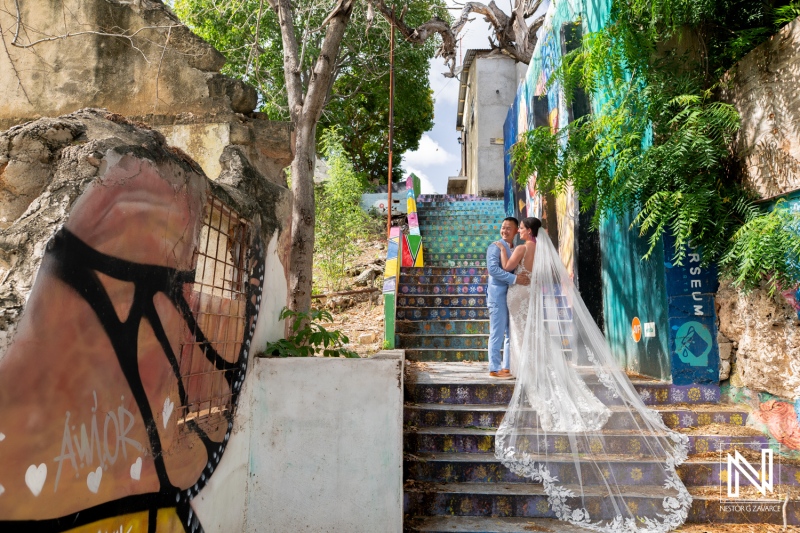 Couple shares a romantic moment on colorful stairs at Kokomo Beach during their wedding in Curacao