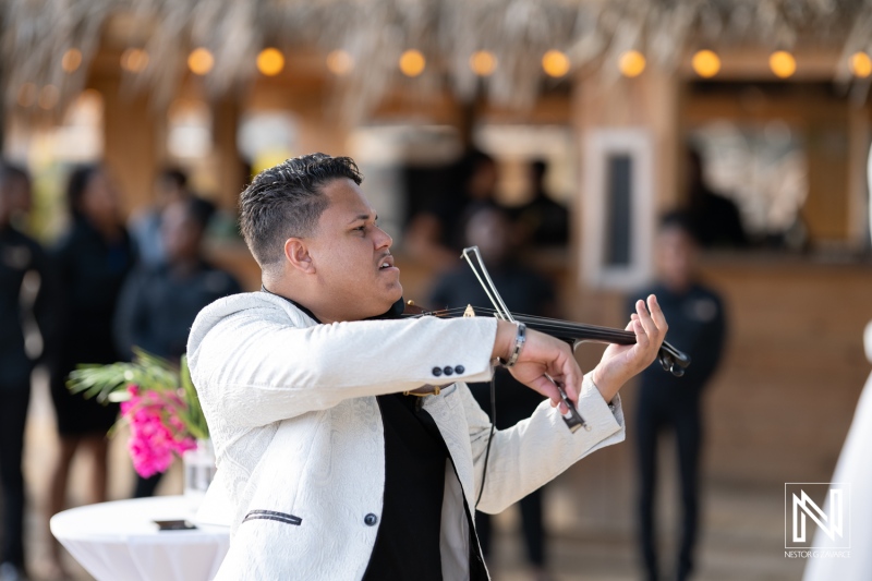 Live violin performance enhances the romantic atmosphere at a wedding celebration on Kokomo Beach in Curacao