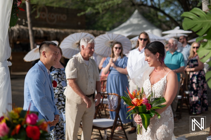 Beautiful wedding ceremony at Kokomo Beach in Curacao with guests gathered under sunny skies