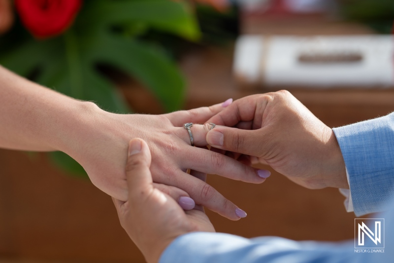 Couple exchanges wedding rings at Kokomo Beach, Curacao during stunning beach ceremony amidst tropical setting