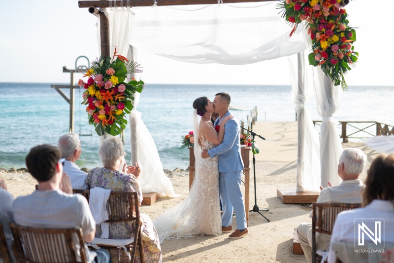 Couples exchange vows during a romantic wedding ceremony at Kokomo Beach in Curacao against a stunning ocean backdrop