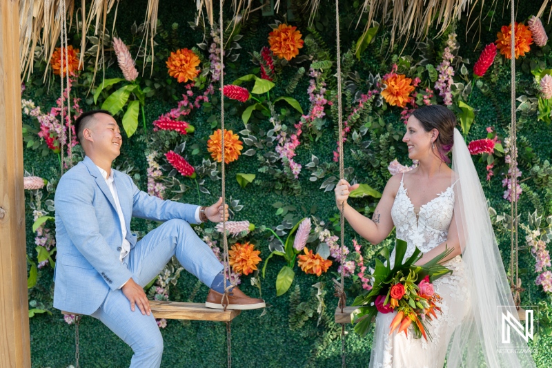 Couple celebrates their love at a beautiful wedding ceremony on Kokomo Beach in Curacao, surrounded by vibrant flowers and joyful moments