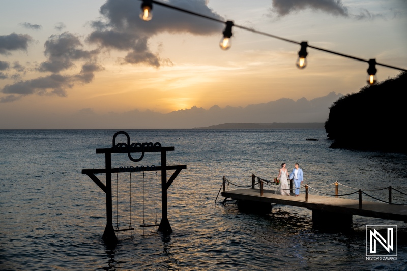Couple exchanges vows during a romantic sunset wedding ceremony at Kokomo Beach in Curacao surrounded by beautiful ocean views