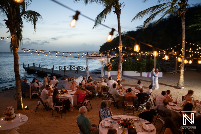 Celebration of love at Kokomo Beach in Curacao during an enchanting evening wedding reception with twinkling lights and palm trees swaying gently