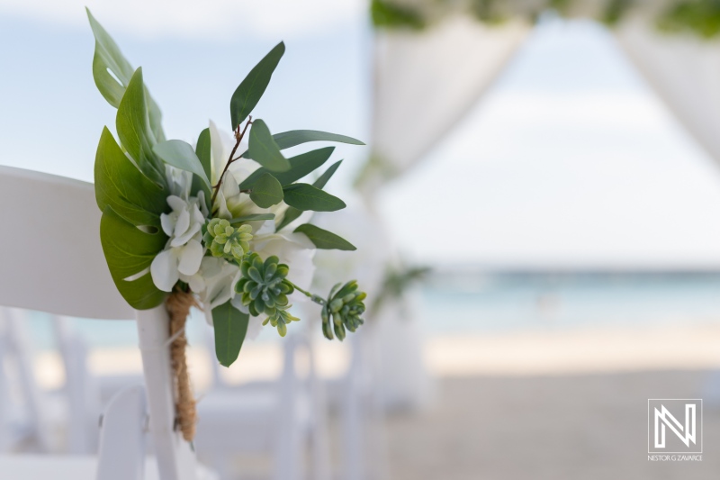 Decorated wedding ceremony chair with floral arrangement overlooking the beach during a sunny afternoon