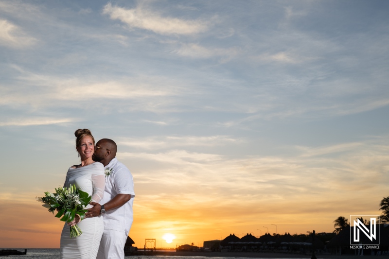 A couple celebrates their wedding on the beach at sunset, surrounded by beautiful nature and a romantic atmosphere in a tropical location