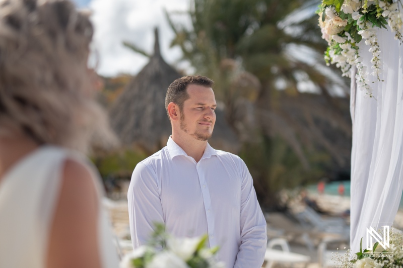 Couple exchanges vows during wedding ceremony at Cas Abao Beach in Curacao on a bright sunny day