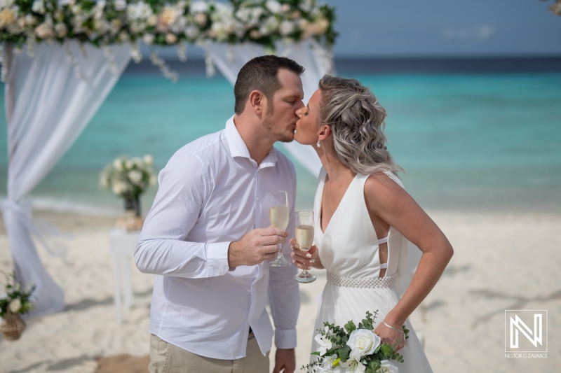 Couple shares a kiss and celebrates during their wedding at Cas Abao Beach in Curacao