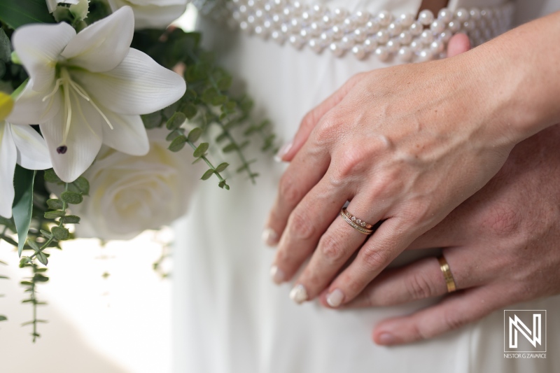 Couple at wedding ceremony holding hands with rings at Cas Abao Beach in Curacao