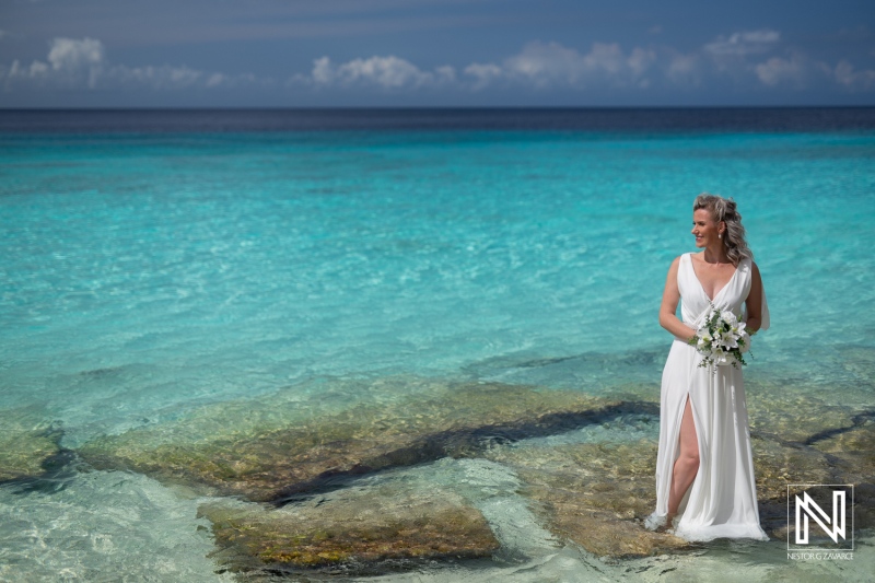 Wedding ceremony at Cas Abao Beach in Curacao with bride standing in water
