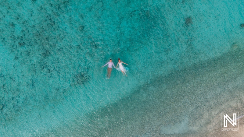 Couple enjoying their wedding day at Cas Abao Beach in Curacao while surrounded by clear blue water