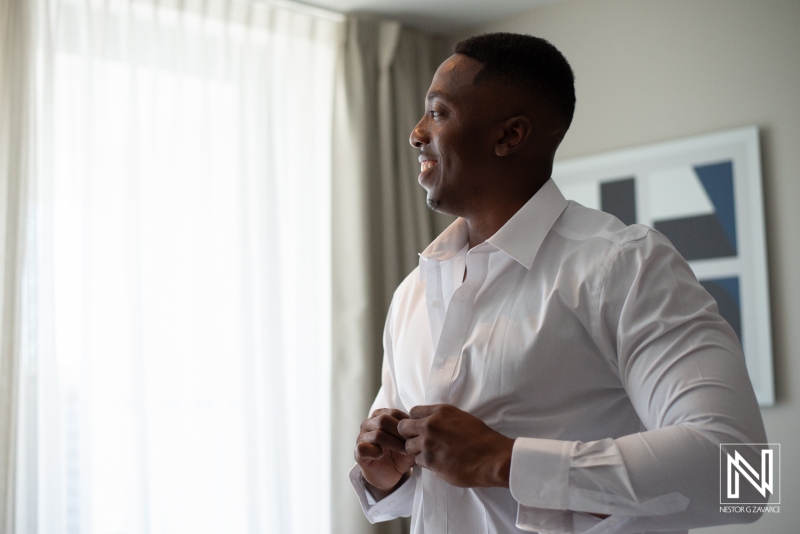 Groom getting into attire