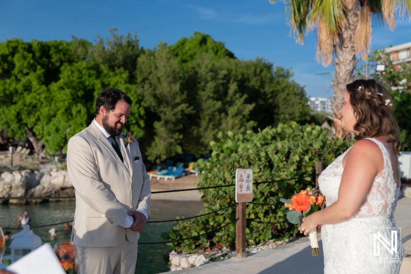 Couple exchanges vows in a romantic wedding ceremony at Dreams Curacao Resort by the beach under a clear blue sky