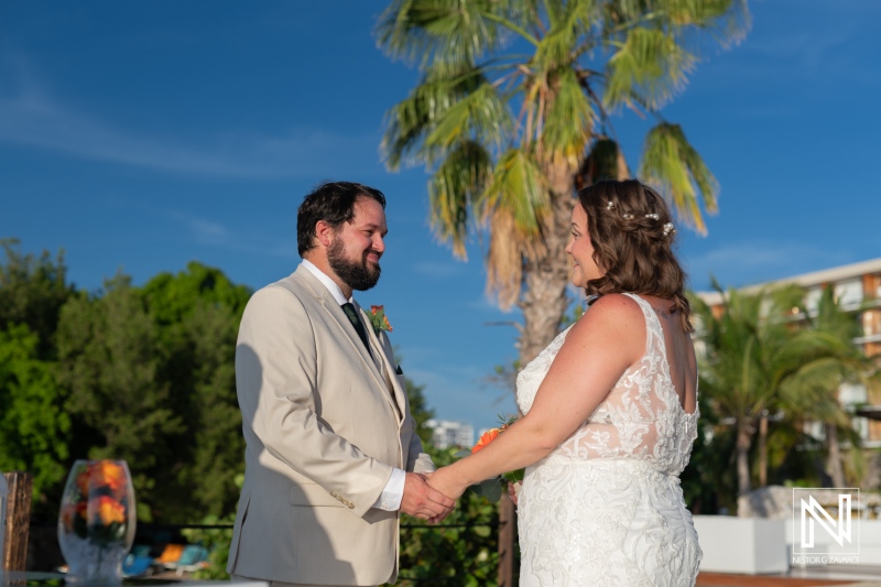 Couple exchanges vows during a romantic wedding ceremony at Dreams Curacao Resort under a clear blue sky