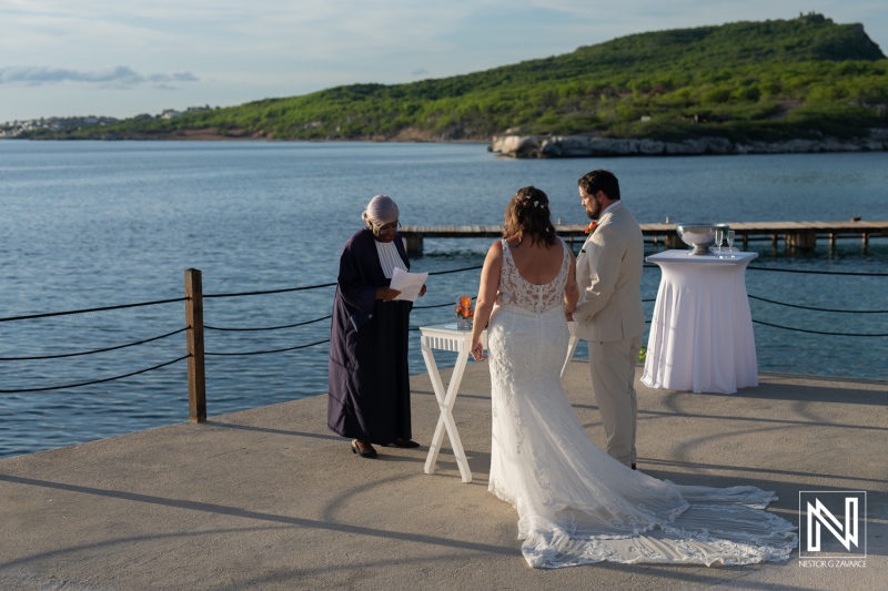 Couple exchanging vows during a romantic wedding ceremony at Dreams Curacao Resort by the serene waters of Curacao