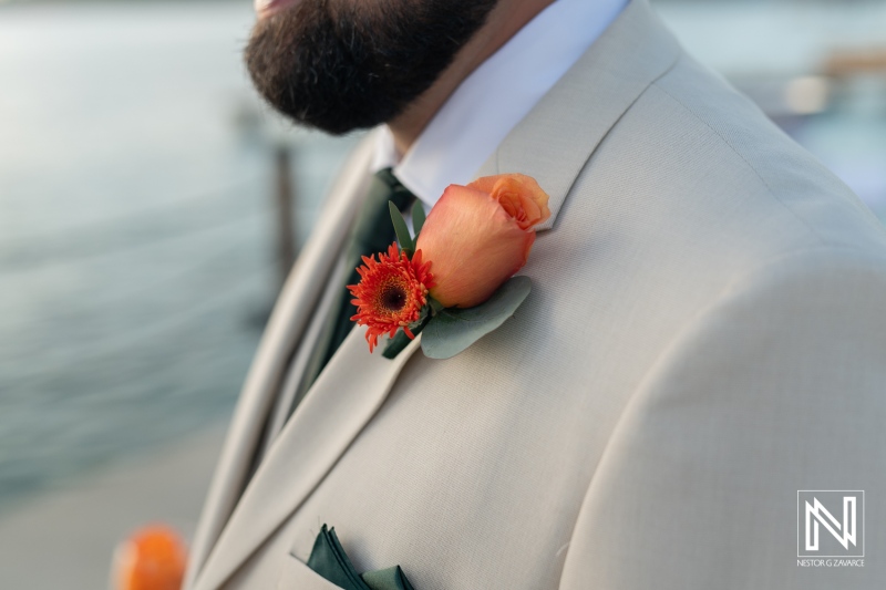 Groom in elegant suit with floral boutonniere at a wedding ceremony in Dreams Curacao Resort