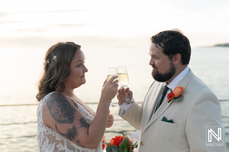 Beautiful couple toasting with champagne during a stunning sunset wedding ceremony in Curacao at Dreams Curacao Resort