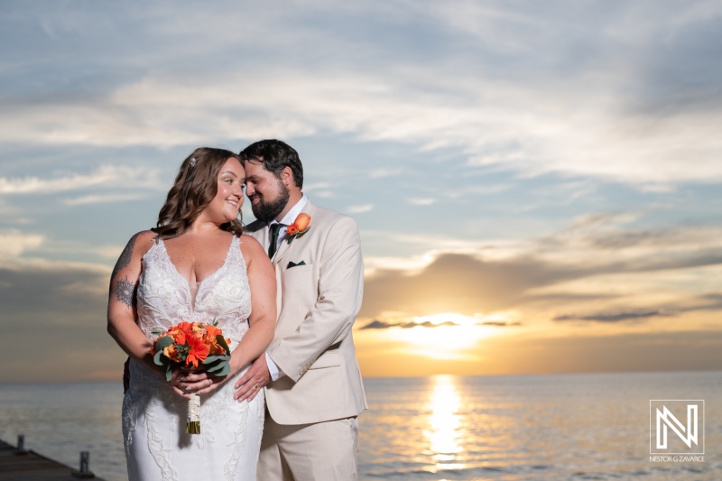 Couple celebrates love during a romantic wedding ceremony at Dreams Curacao Resort under a picturesque sunset sky