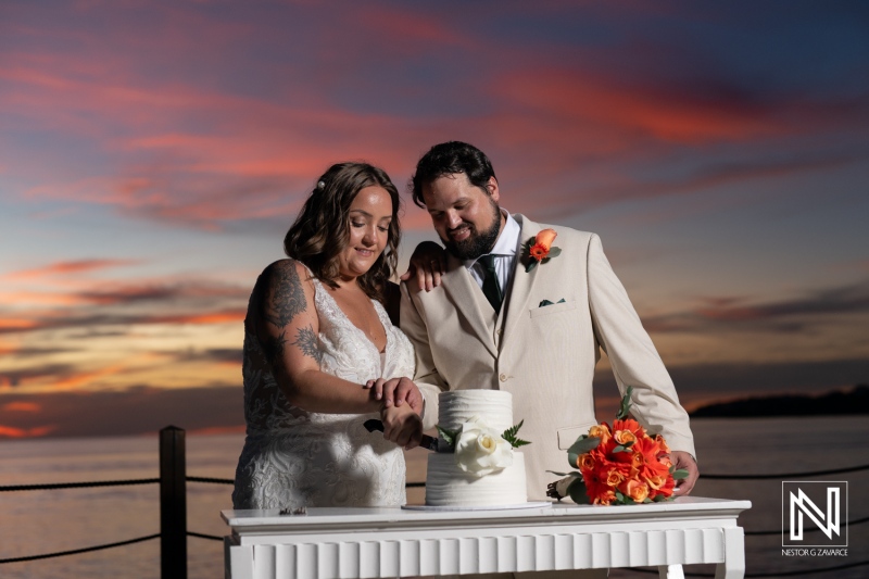 Celebrating love with a beautiful wedding cake at Dreams Curacao Resort during sunset