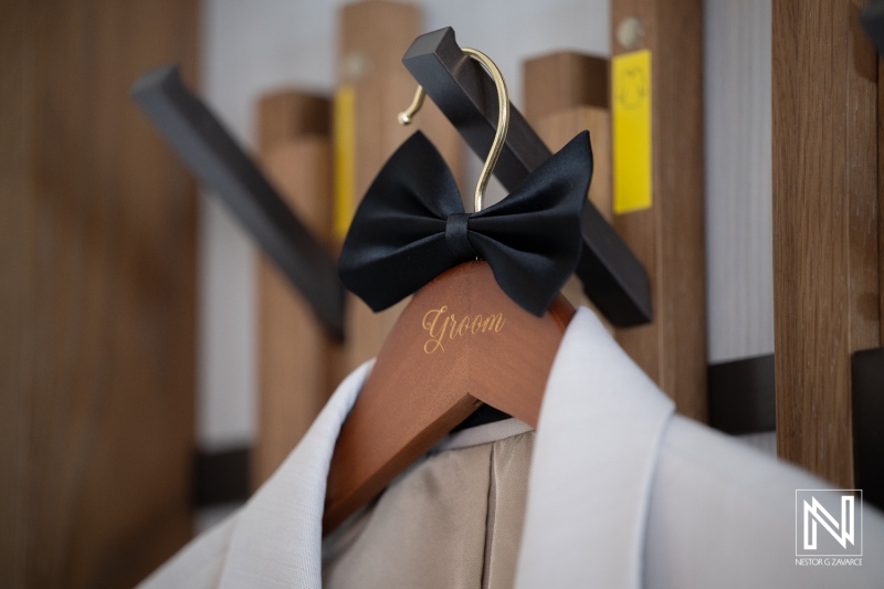 Groom's bow tie hangs on a hook at Renaissance Wind Creek Curacao Resort during wedding preparation