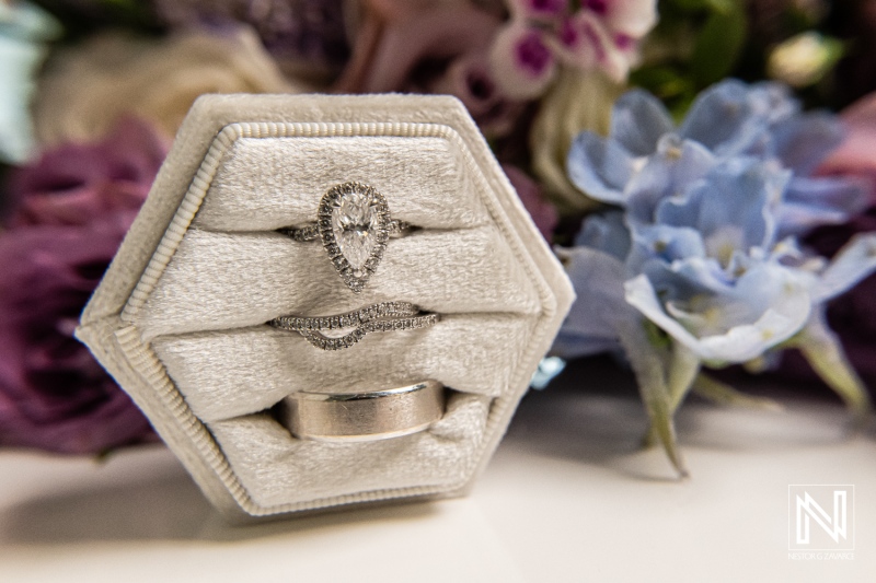Wedding rings on display at Renaissance Wind Creek Curacao Resort during a wedding ceremony with floral decorations