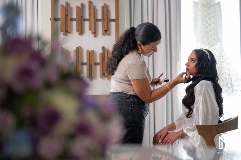 Bride prepares for wedding ceremony at Renaissance Wind Creek Curacao Resort with makeup artist in private suite