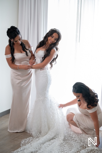 Bridesmaids help the bride get ready at Renaissance Wind Creek Curacao Resort before the wedding ceremony