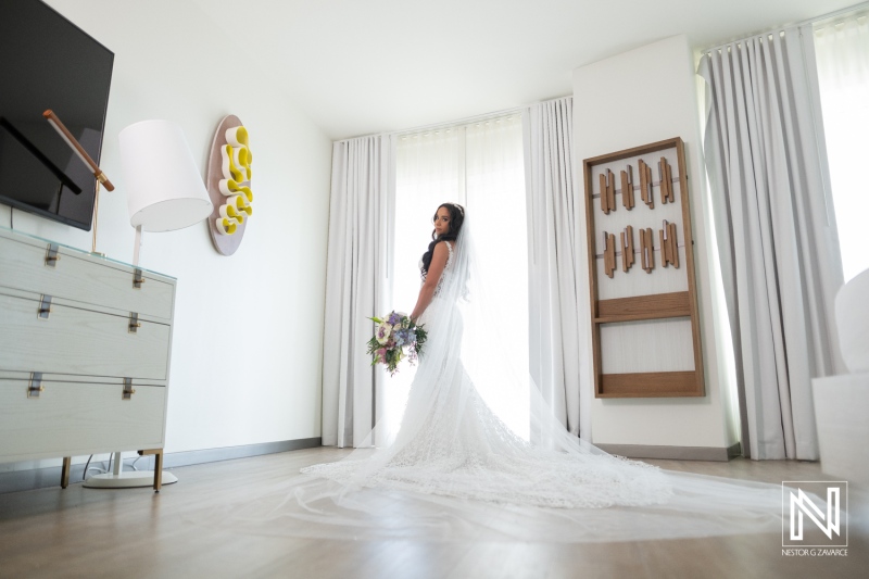 Bride prepares for wedding at Renaissance Wind Creek Curacao Resort in a bright room with floral bouquet