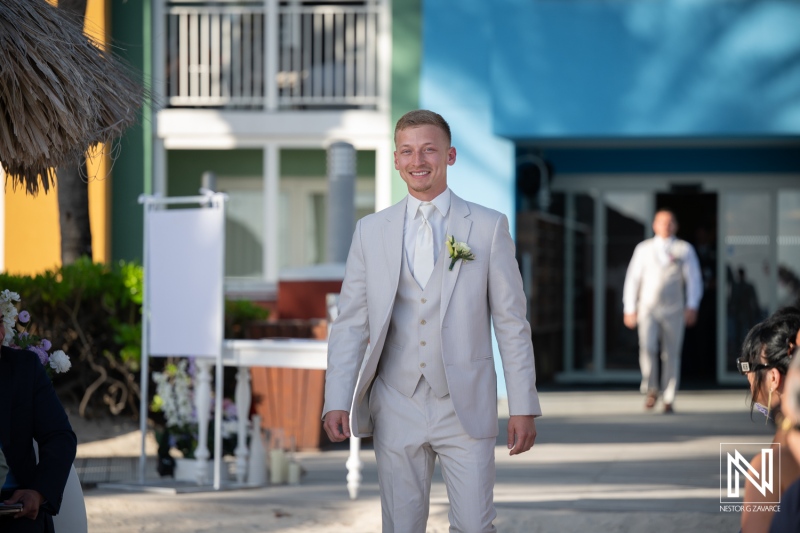 Groom walking towards the wedding ceremony at Renaissance Wind Creek Curacao Resort with guests in attendance