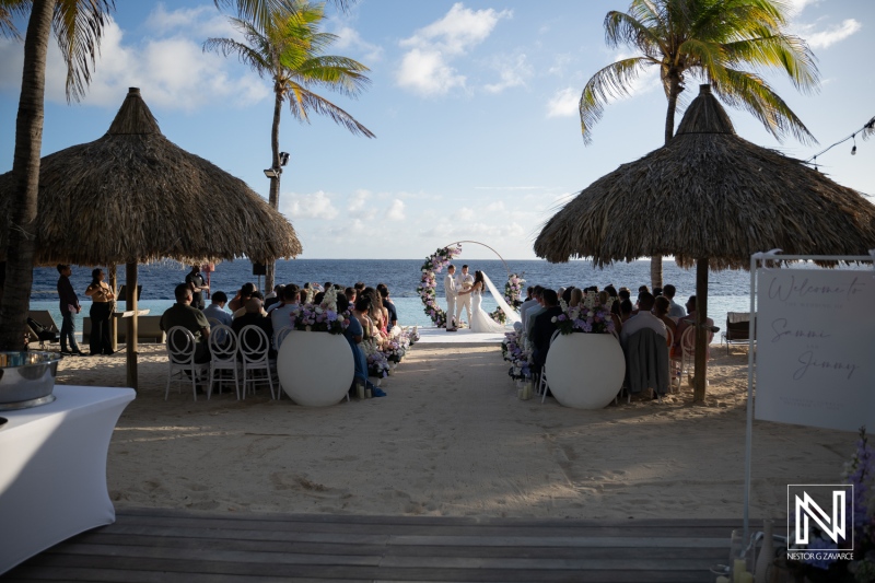 Couple exchanges vows by the ocean during their wedding ceremony at Renaissance Wind Creek Curacao Resort
