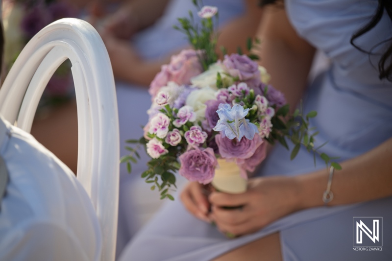 Flower arrangements held by guests at a wedding ceremony at Renaissance Wind Creek Curacao Resort in Curacao during a sunny day
