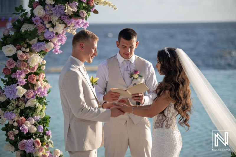 Couple exchanges vows during wedding ceremony at Renaissance Wind Creek Curacao Resort near the ocean