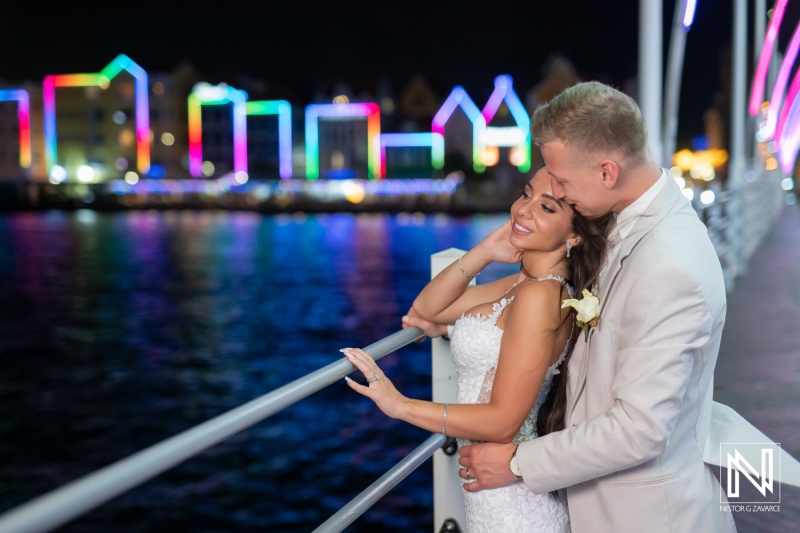 Couple enjoys a romantic moment at their wedding by the water at Renaissance Wind Creek Curacao Resort during the night