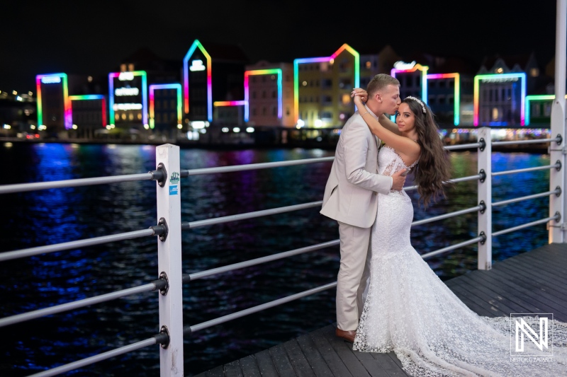 Couple shares a moment on the pier during their wedding at Renaissance Wind Creek Curacao Resort at night