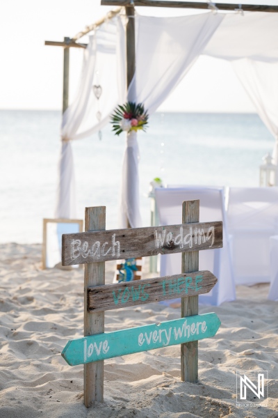 Wedding ceremony setup at Daaibooi Beach in Curacao featuring a sign and decoration