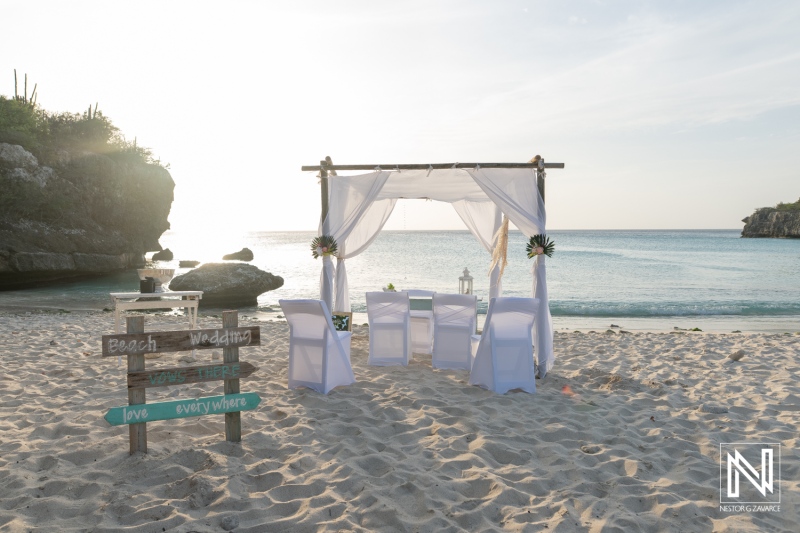 Wedding setup at Daaibooi Beach in Curacao during sunset with chairs and decorations