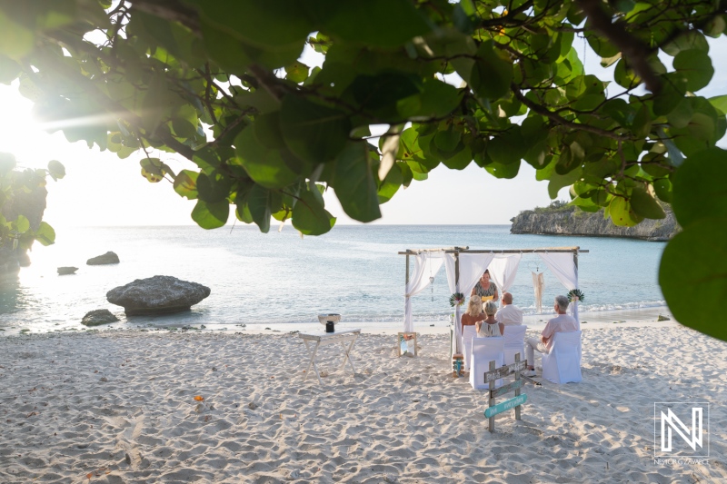 Wedding ceremony at Daaibooi Beach in Curacao with guests seated on the sand near the ocean