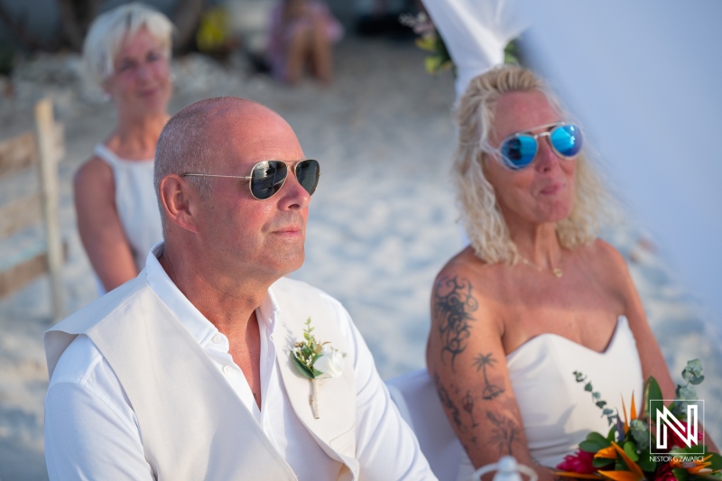 Wedding ceremony at Daaibooi Beach in Curacao with guests seated on the sand