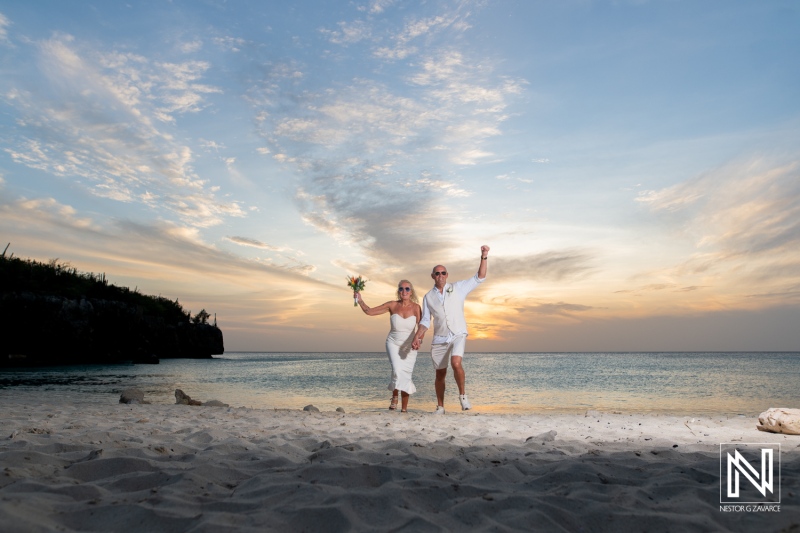 Couple celebrates wedding at Daaibooi Beach during sunset in Curacao with joy and happiness