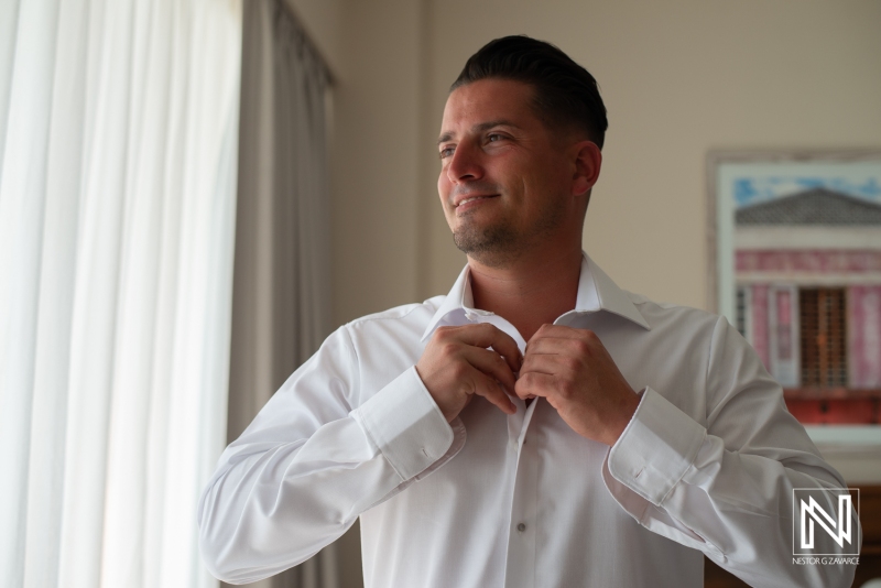 Groom getting into attire