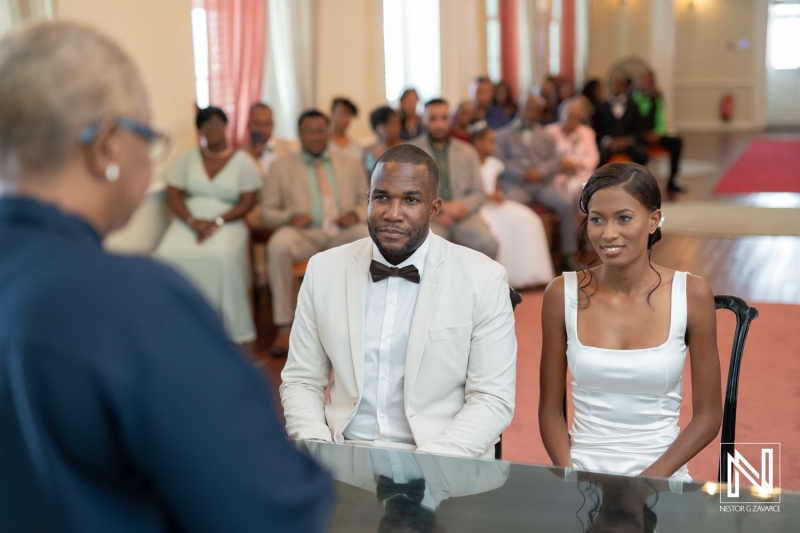 A couple exchanging vows during their wedding ceremony in a beautifully decorated hall filled with family and friends celebrating their special day