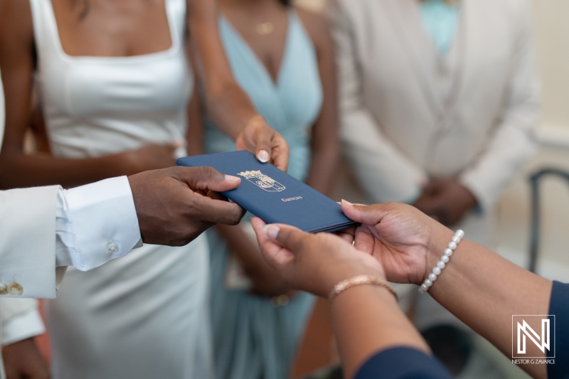 Couple exchanging marriage certificate during intimate wedding ceremony in an elegant venue with friends and family gathered in support