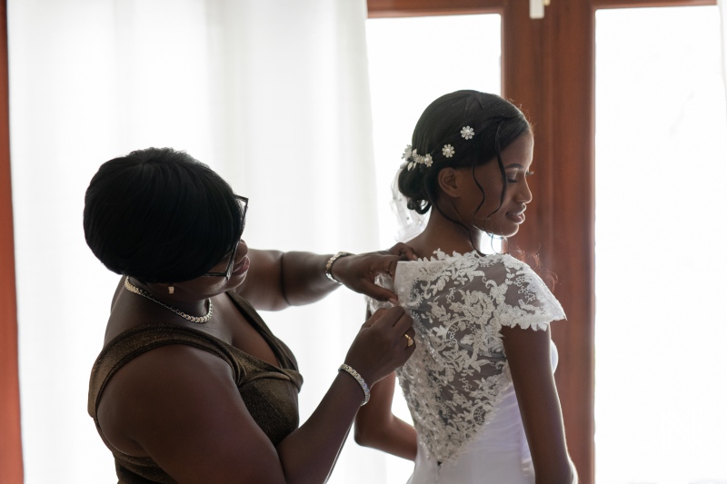 A mother helping her daughter with wedding dress preparation in a bright and elegant room before the ceremony