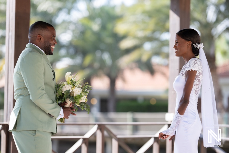 Couple exchanging vows in an outdoor wedding ceremony surrounded by lush greenery on a sunny day, capturing a moment of joy and love