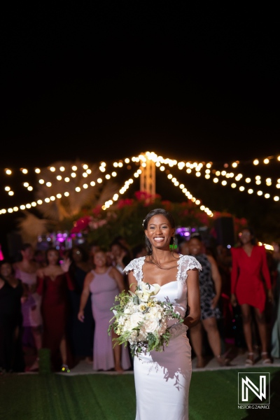 Beautiful bride joyfully walks down the aisle at a vibrant outdoor wedding reception at night with twinkling lights and elegant guests in attendance