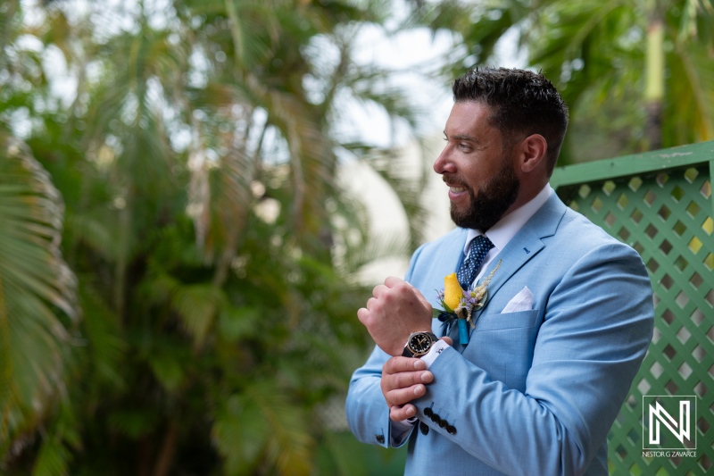 Groom prepares with confidence at Sunscape Curacao Resort amid lush tropical scenery before wedding ceremony