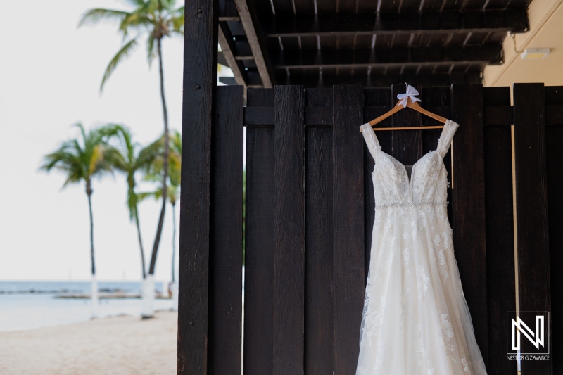 Wedding dress displayed at Sunscape Curacao Resort overlooking the serene beach and palm trees on a beautiful day