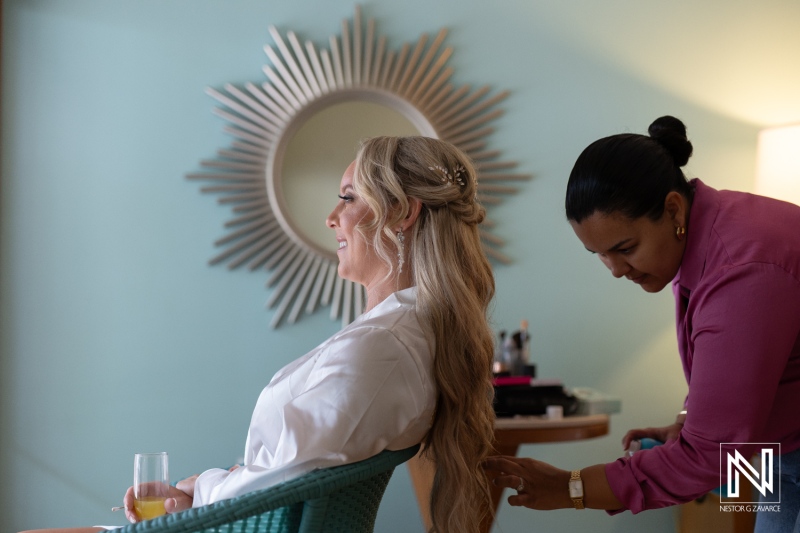 Bride preparing for wedding ceremony at Sunscape Curacao Resort with hairstylist in a vibrant setting